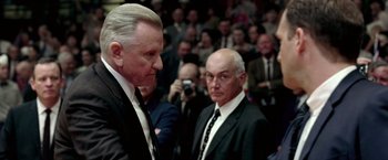 Movie still from “Glory Road” (2006), directed by James Gartner – Two men in suits and ties standing next to each other in front of an audience; Close Up shot, Over the shoulder angle