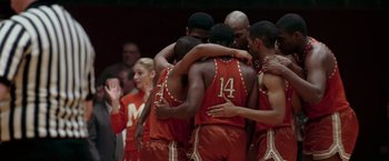 Movie still from “Glory Road” (2006), directed by James Gartner – A group of basketball players huddled together in a huddle; Medium shot, High angle