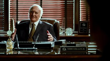 An older man sitting at a desk in an office