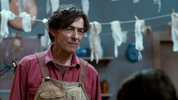 A man in a red shirt is standing in a room