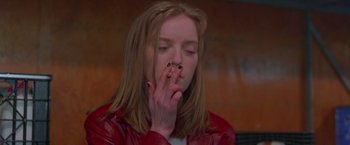 Movie still from “Go” (1999), directed by Doug Liman – A woman in a red leather jacket smoking a cigarette; Close Up shot, Low angle