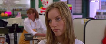 Movie still from “Go” (1999), directed by Doug Liman – A woman with long hair sitting in front of a window; Close Up shot, Over the shoulder angle