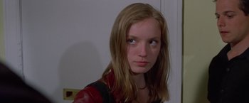 Movie still from “Go” (1999), directed by Doug Liman – A young woman with long blonde hair wearing a red leather jacket; Close Up shot, Over the shoulder angle