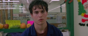 Movie still from “Go” (1999), directed by Doug Liman – A young man in a blue shirt is looking at the camera; Close Up shot, Low angle