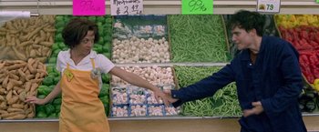 Movie still from “Go” (1999), directed by Doug Liman – Two people shaking hands in front of a display of vegetables in a store; Medium shot, Overhead angle