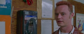 Movie still from “Go” (1999), directed by Doug Liman – A man standing in front of a pay phone; Close Up shot, Low angle