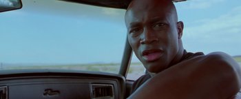 Movie still from “Go” (1999), directed by Doug Liman – A person in a car; Close Up shot, Low angle