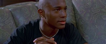 Movie still from “Go” (1999), directed by Doug Liman – A person sitting down with his hands clasped; Close Up shot, High angle