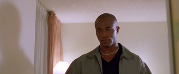 Movie still from “Go” (1999), directed by Doug Liman – A man in a black shirt and a brown jacket; Close Up shot, Low angle
