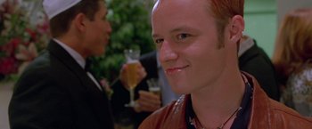 Movie still from “Go” (1999), directed by Doug Liman – A person holding a glass of wine; Close Up shot, Low angle