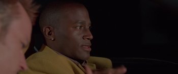 Movie still from “Go” (1999), directed by Doug Liman – A person wearing a yellow jacket; Close Up shot, Over the shoulder angle