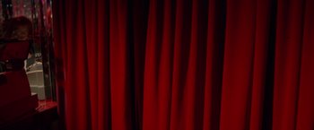 Movie still from “Go” (1999), directed by Doug Liman – View of a red curtain; Extreme Wide shot, Low angle