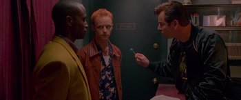 Movie still from “Go” (1999), directed by Doug Liman – Two men standing next to each other in front of a door; Medium shot, Over the shoulder angle