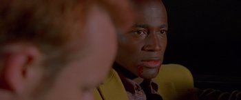 Movie still from “Go” (1999), directed by Doug Liman – A person with blood on his face; Close Up shot, Over the shoulder angle