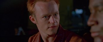 Movie still from “Go” (1999), directed by Doug Liman – A person with red hair; Close Up shot, Low angle