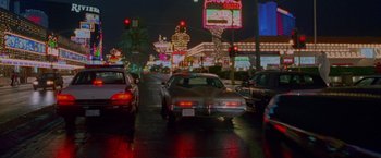 Movie still from “Go” (1999), directed by Doug Liman – A street filled with lots of traffic at night time; Extreme Wide shot, High angle