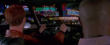 Movie still from “Go” (1999), directed by Doug Liman – A person driving a car at night in the dark; Medium shot, Over the shoulder angle