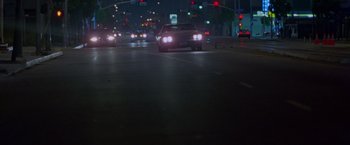 Movie still from “Go” (1999), directed by Doug Liman – Cars driving down a street at night with a traffic light; Extreme Wide shot, High angle