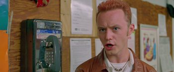 Movie still from “Go” (1999), directed by Doug Liman – A man with red hair is standing in front of a pay phone; Close Up shot, Low angle