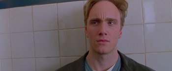 Movie still from “Go” (1999), directed by Doug Liman – A person looking at the camera; Close Up shot, Low angle