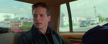 Movie still from “Go” (1999), directed by Doug Liman – A man sitting in the back seat of a car; Close Up shot, Low angle