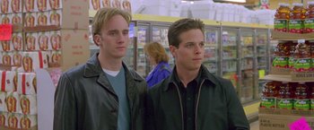 Movie still from “Go” (1999), directed by Doug Liman – A couple of men standing next to each other in a store; Medium shot, Low angle