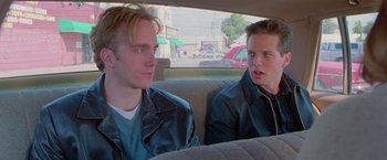 Movie still from “Go” (1999), directed by Doug Liman – Two young men sitting in the back seat of a car; Close Up shot, Over the shoulder angle