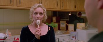 Movie still from “Go” (1999), directed by Doug Liman – A woman is holding a donut in her mouth; Close Up shot, High angle