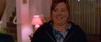 Movie still from “Go” (1999), directed by Doug Liman – A person smiling at the camera; Close Up shot, Over the shoulder angle