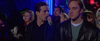 Movie still from “Go” (1999), directed by Doug Liman – A group of young men standing next to each other in a room; Close Up shot, Low angle