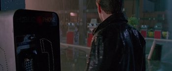 Movie still from “Go” (1999), directed by Doug Liman – A man wearing a leather jacket standing next to a parking meter; Medium shot, Over the shoulder angle