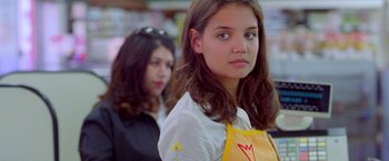 Movie still from “Go” (1999), directed by Doug Liman – A girl with a yellow apron is standing in front of another girl; Close Up shot, Over the shoulder angle