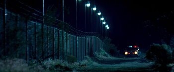 Movie still from “Goal! The Dream Begins” (2005), directed by Michael Winterbottom – A row of street lights hanging over a fence; Extreme Wide shot, Low angle