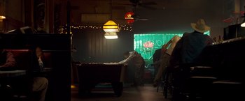 Movie still from “Goal! The Dream Begins” (2005), directed by Michael Winterbottom – A man is playing pool in a room with lights; Wide shot, Low angle