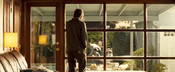 Movie still from “Goal! The Dream Begins” (2005), directed by Michael Winterbottom – A man standing in front of an open window; Wide shot, Over the shoulder angle