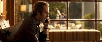 Movie still from “Goal! The Dream Begins” (2005), directed by Michael Winterbottom – A man sitting at a table talking on a cell phone; Close Up shot, Over the shoulder angle