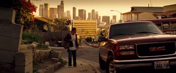 Movie still from “Goal! The Dream Begins” (2005), directed by Michael Winterbottom – A man standing on the side of the road next to a truck; Wide shot, Low angle