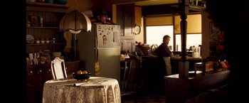 Movie still from “Goal! The Dream Begins” (2005), directed by Michael Winterbottom – Two people are in a kitchen with a refrigerator and a table; Wide shot, Low angle