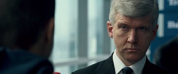 Movie still from “Goal! The Dream Begins” (2005), directed by Michael Winterbottom – A man in a suit and tie in a room; Close Up shot, Over the shoulder angle