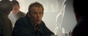 Movie still from “Goal! The Dream Begins” (2005), directed by Michael Winterbottom – An older man sitting at a table with a cup of coffee; Close Up shot, Over the shoulder angle