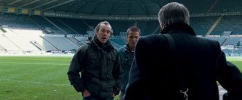 Movie still from “Goal! The Dream Begins” (2005), directed by Michael Winterbottom – A group of men standing on top of a soccer field; Medium shot, Over the shoulder angle