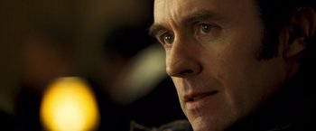 Movie still from “Goal! The Dream Begins” (2005), directed by Michael Winterbottom – A man's face in a dimly - lit room; Extreme Close Up shot, Over the shoulder angle