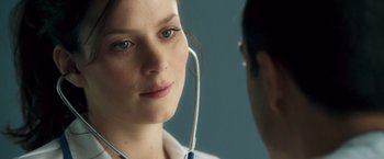 Movie still from “Goal! The Dream Begins” (2005), directed by Michael Winterbottom – A woman with a stethoscope around her neck looking into a mirror; Close Up shot, Over the shoulder angle
