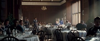 Movie still from “Goal! The Dream Begins” (2005), directed by Michael Winterbottom – People are sitting at tables in a large room; Wide shot, Low angle