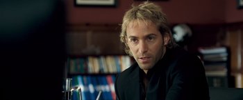 Movie still from “Goal! The Dream Begins” (2005), directed by Michael Winterbottom – A person wearing a suit and tie; Close Up shot, Over the shoulder angle