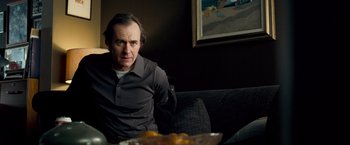 Movie still from “Goal! The Dream Begins” (2005), directed by Michael Winterbottom – A man sitting on a couch in front of a bowl of oranges; Medium shot, Over the shoulder angle