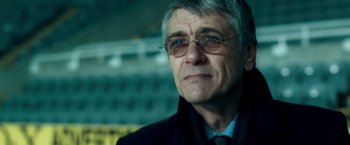Movie still from “Goal! The Dream Begins” (2005), directed by Michael Winterbottom – An older man wearing glasses and a jacket; Close Up shot, Low angle