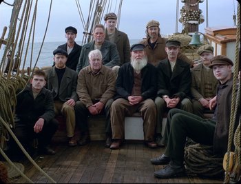 A group of men sitting on top of a wooden boat