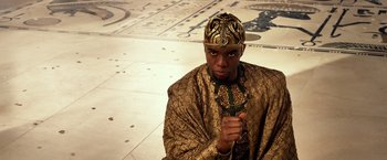 Movie still from “Gods of Egypt” (2016), directed by Alex Proyas – A man wearing a gold crown and a gold robe; Medium shot, Low angle