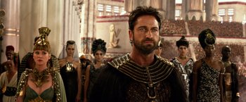 Movie still from “Gods of Egypt” (2016), directed by Alex Proyas – A group of people standing in a room; Close Up shot, Over the shoulder angle